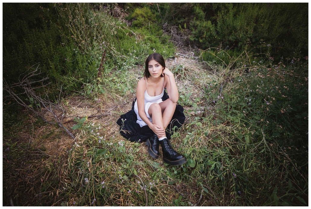 High school senior sitting in a field for a photoshoot in Laguna Beach