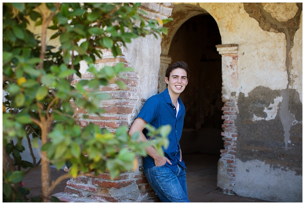 High School senior guy posing in an archway in the Mission in San Juan Capistrano