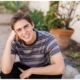 High School senior guy squatting pose in the Mission in San Juan Capistrano