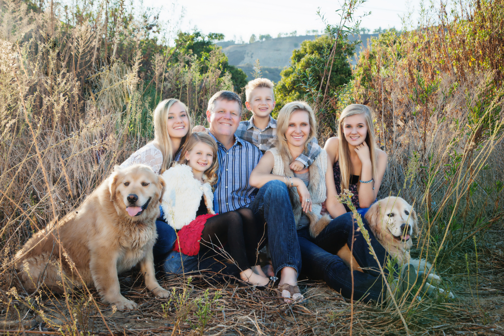Family of six photography session in San Juan Capistrano including posing with their pet, which are two golden retriever dogs