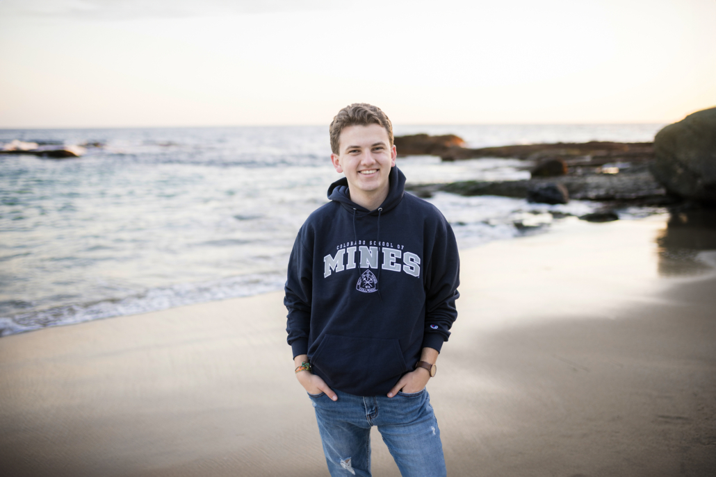 An image answering the questions of what to wear to a senior session on the beach. It is a great idea to incorporate college gear.