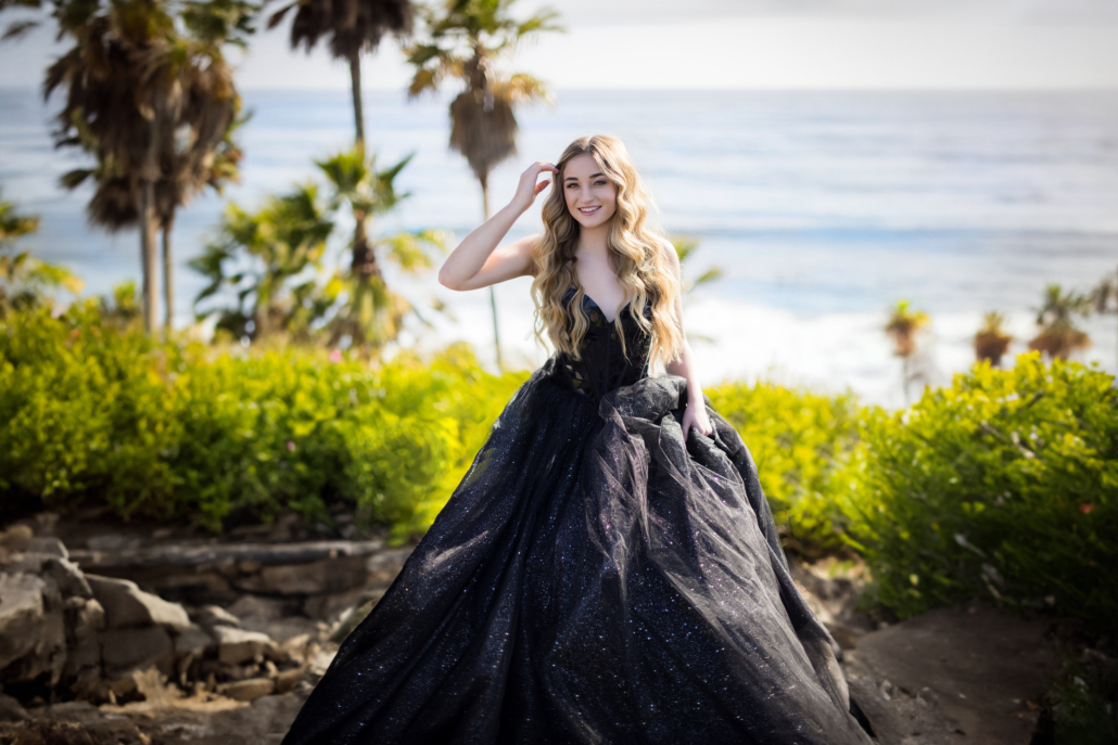 An image of an orange county high school senior portrait at the beach wearing her prom dress. The location is Heisler park in Laguna Beach