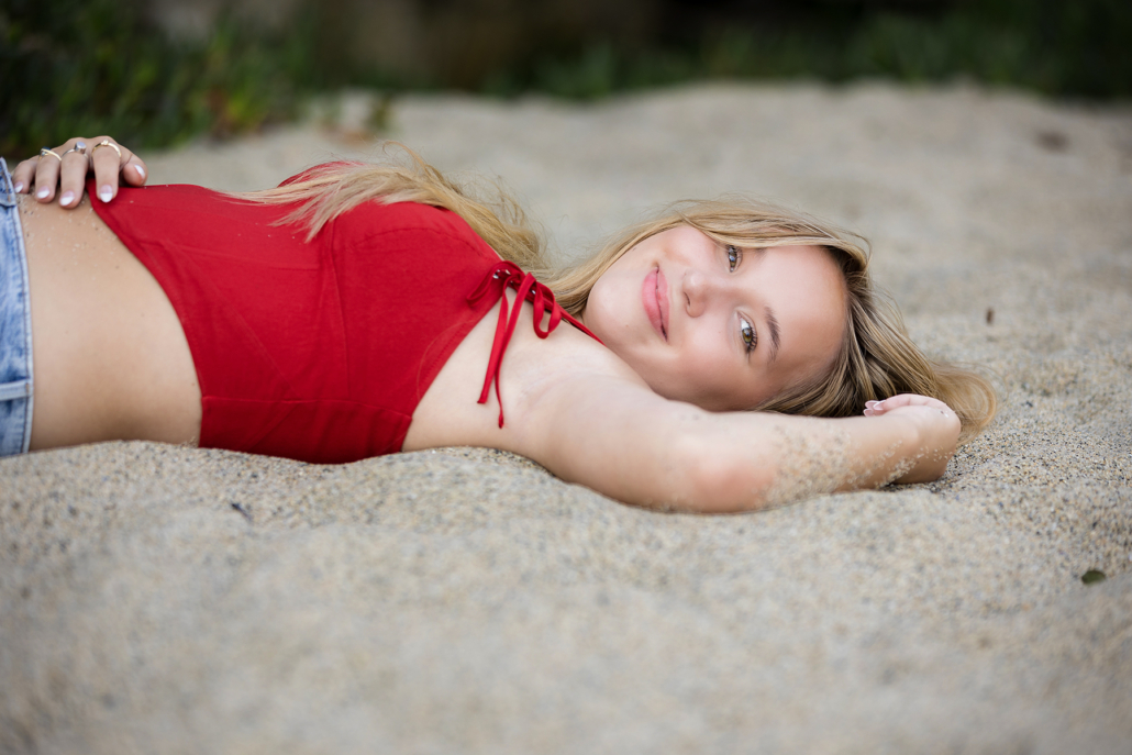 High school senior from Michigan traveled to Laguna Beach for her High school senior portrait session. She wore bold colors on the sand at Tablerock beach to bring all the focus of the photographs on to her.