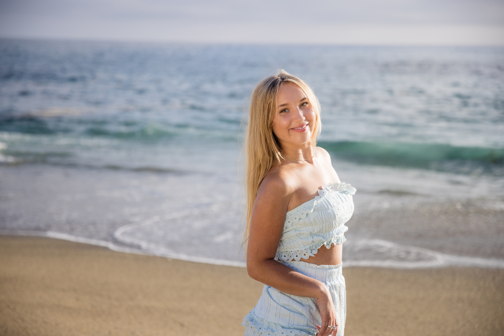 Golden backlit image of a high school senior from the class of 2024 at Tablerock beach. This is the perfect location at sunset for a destination high school senior session.