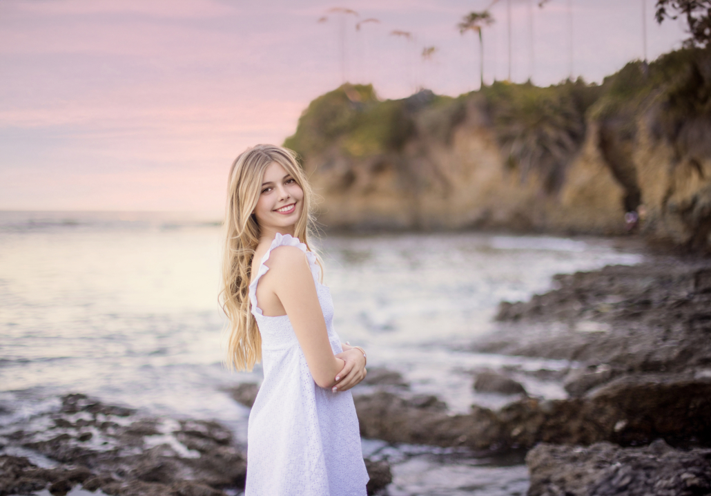 Professional Senior Photography at Crescent Bay Beach featuring a girl at sunset in a white dress.