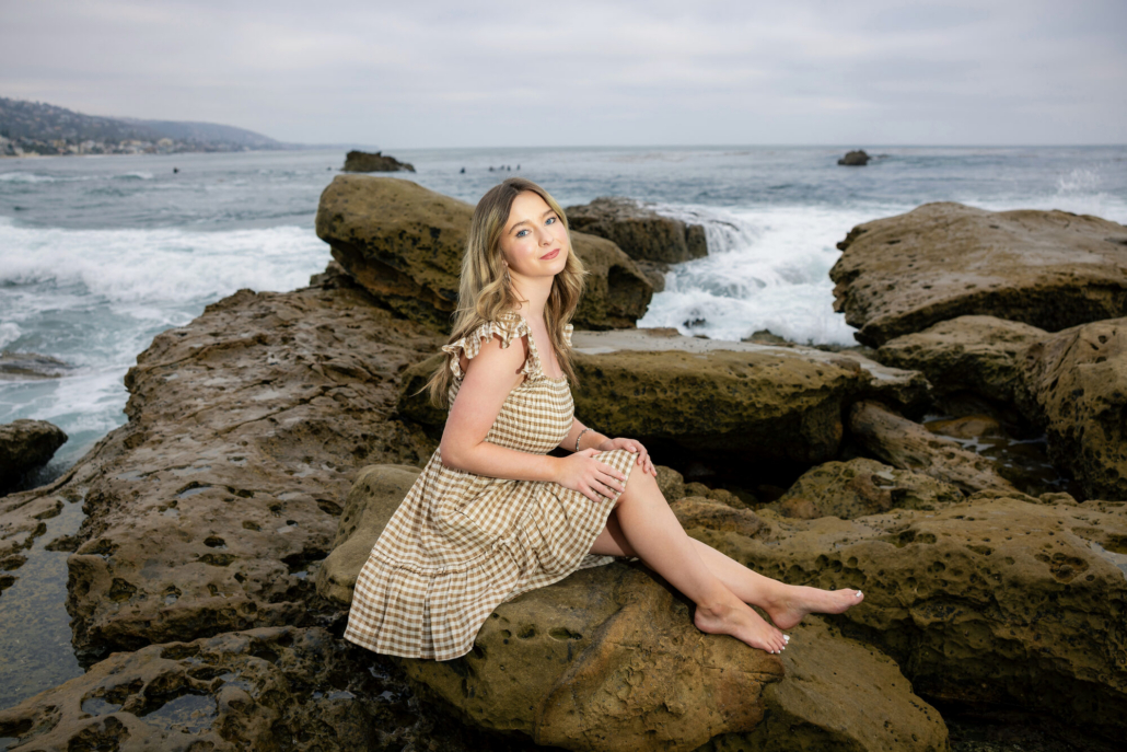 Senior photo of Cici on the rocky cliffs at Rockpile Beach in Laguna Beach