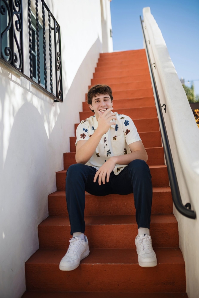 Senior guy laughing on the terracotta steps during his San Clemente urban session