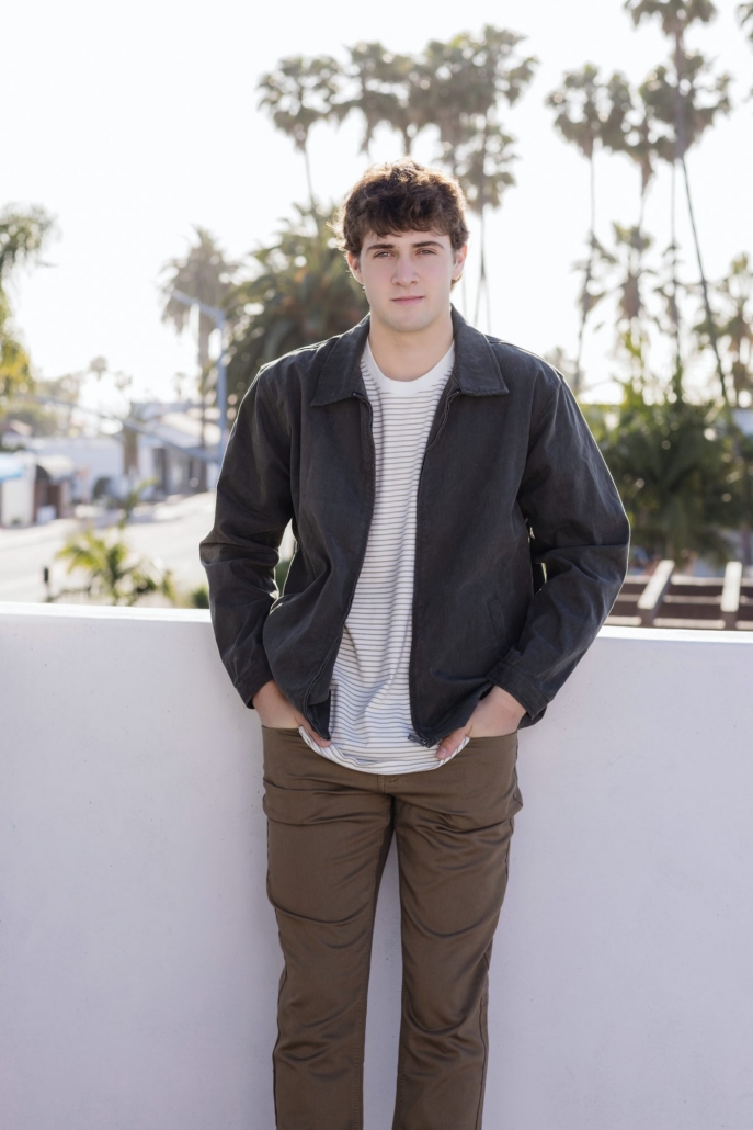 San Clemente senior guy on a rooftop with palm trees and the coastal skyline behind him