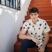 Senior guy in a floral shirt sitting on a terracotta Spanish staircase in San Clemente
